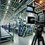 Modern bir fabrikada çalışan işçiler ve ileri teknoloji üretim makineleri, profesyonel bir kamera ekibi tarafından çekim yapılıyor.